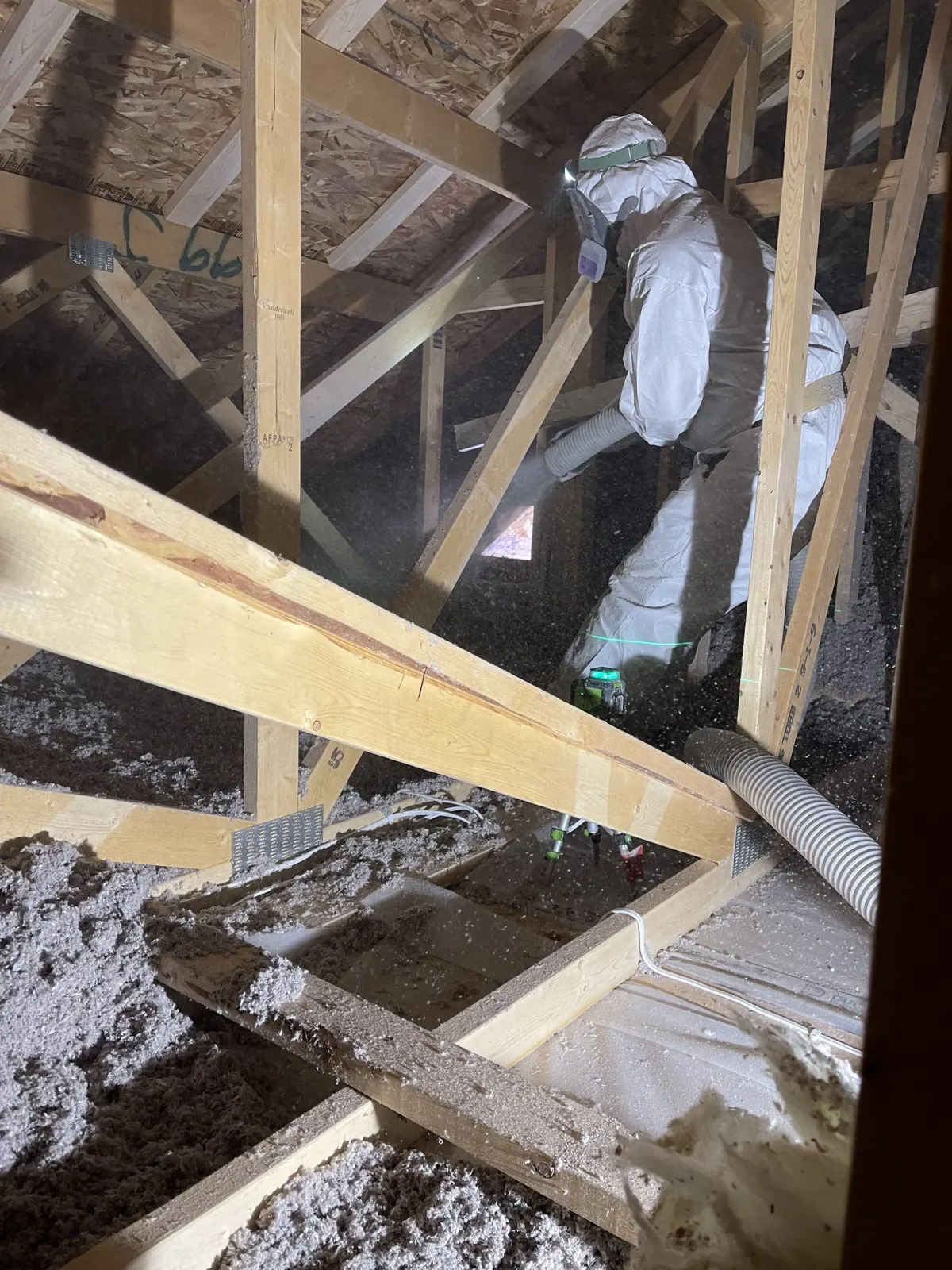 Installer blowing loose-fill insulation into an attic
