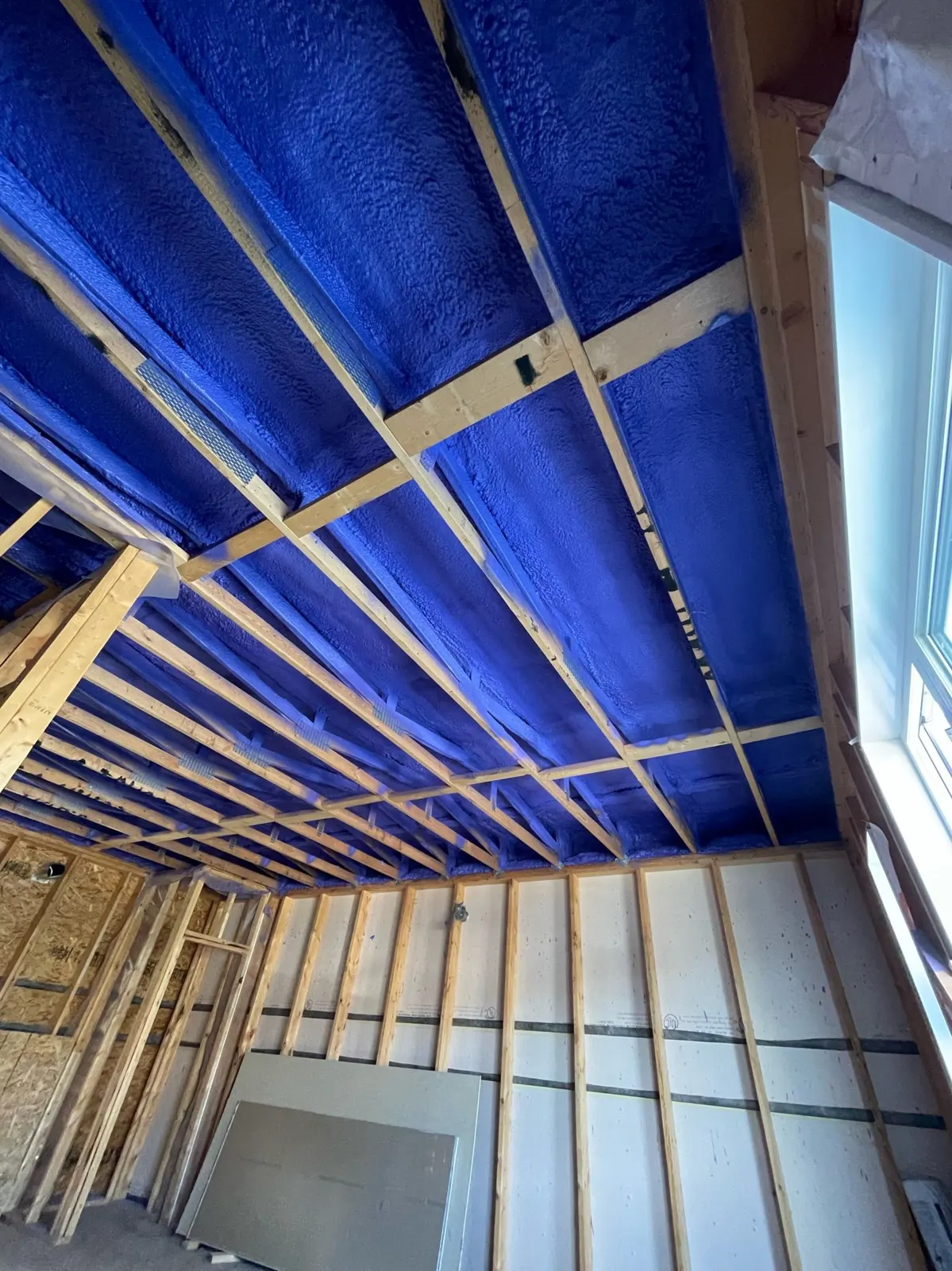 Closed cell foam installed between ceiling joists in a framed space