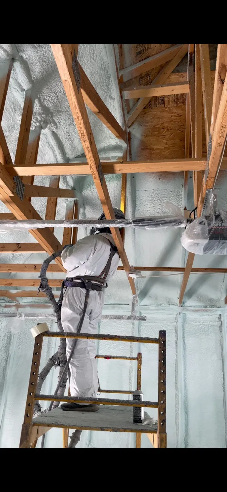 Commercial ceiling being sprayed from access equipment