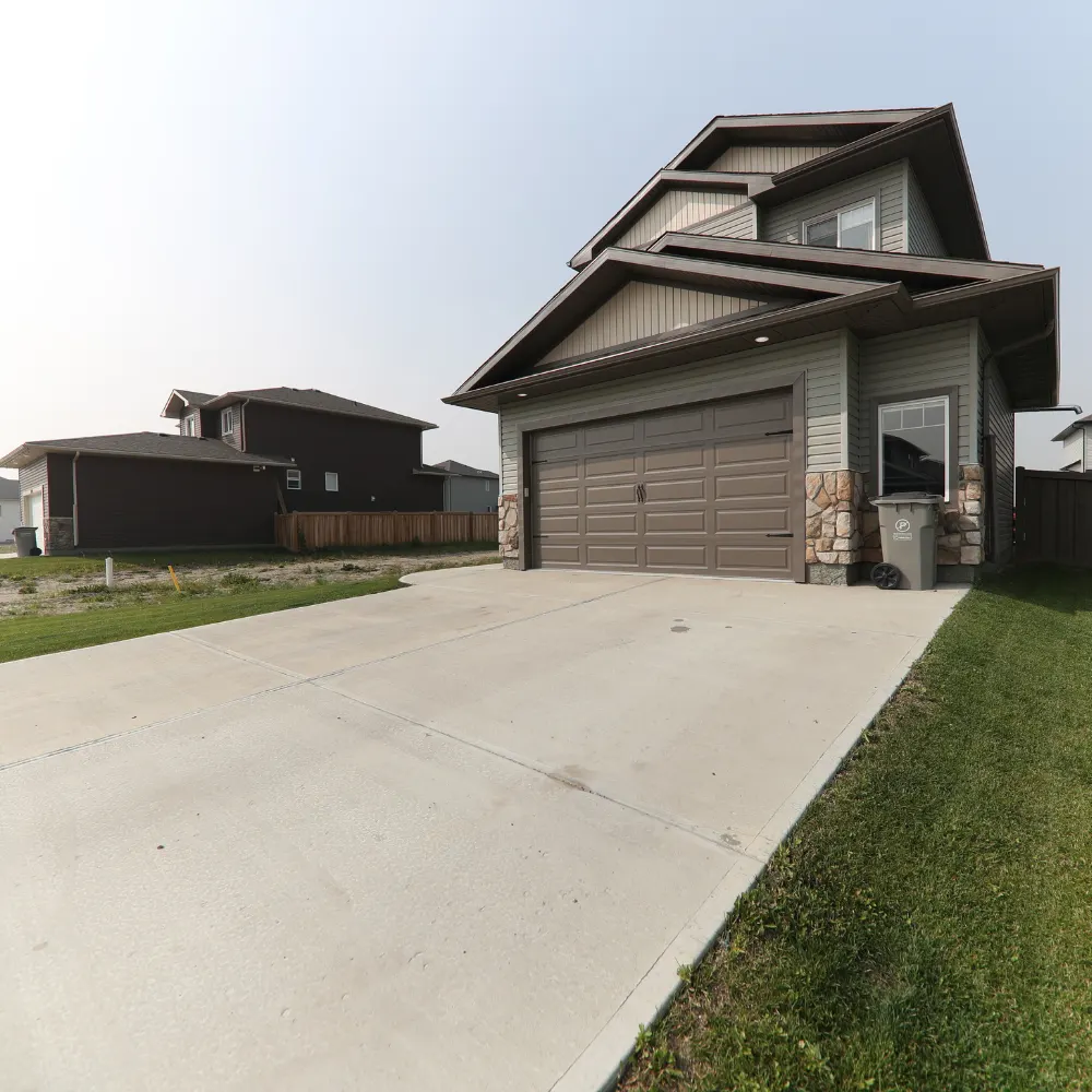 Two-storey house with a long concrete driveway and garage